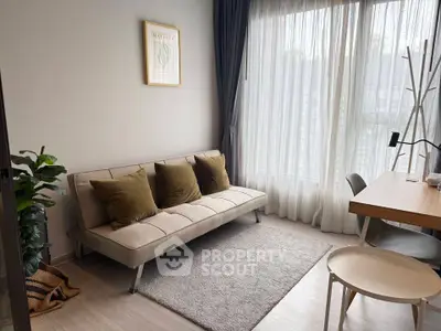 Modern living room with cozy sofa, stylish decor, and natural light from large window.