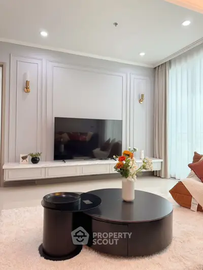 Elegant living room with modern decor and large TV, perfect for relaxation.