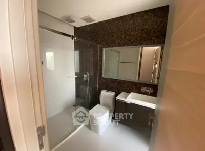 Modern bathroom with glass shower and sleek fixtures in a contemporary home.