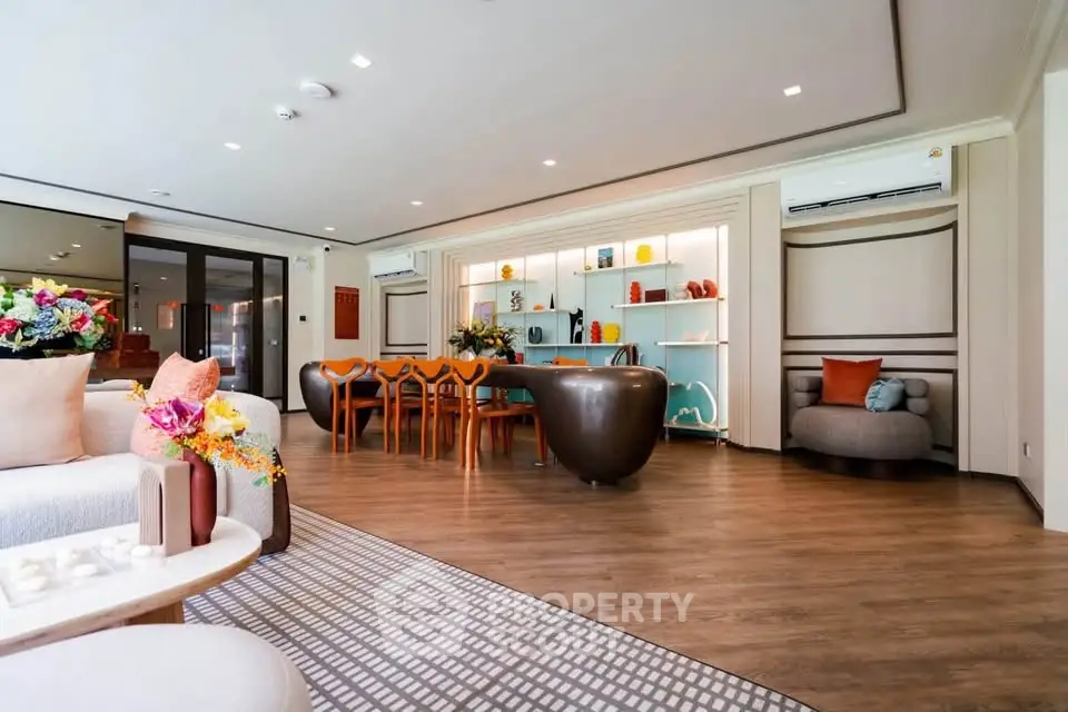 Spacious modern living room with elegant decor and open layout, featuring stylish furniture and vibrant accents.