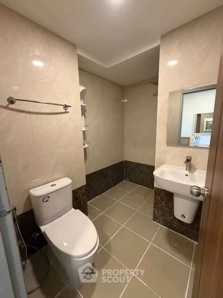 Modern bathroom with sleek fixtures and neutral tiles, perfect for a contemporary home.