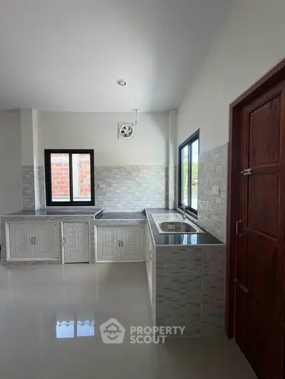 Modern kitchen with sleek cabinetry and ample natural light, perfect for culinary enthusiasts.