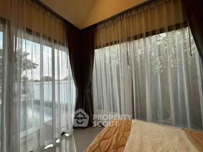 Luxurious bedroom with pool view and elegant curtains, perfect for relaxation.