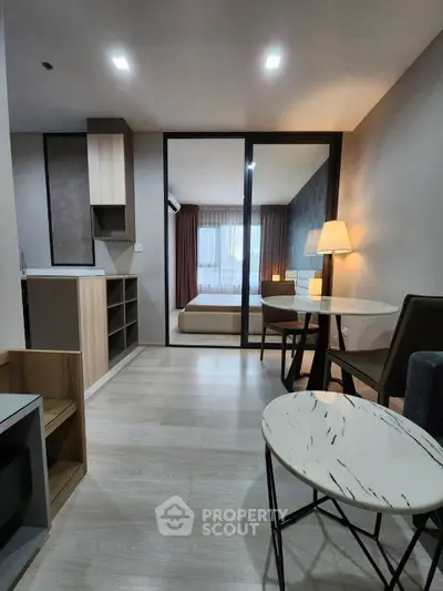 Modern open-plan living area with stylish furniture and bedroom view