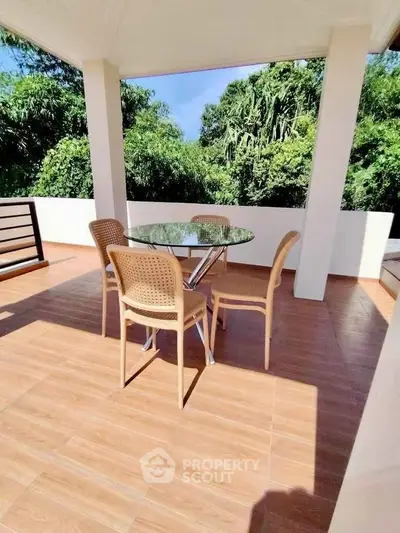 Spacious balcony with outdoor dining set and lush green view