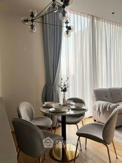 Elegant dining area with modern chandelier and cozy seating in a bright living room.