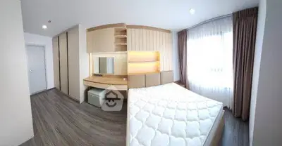 Spacious modern bedroom with large window and stylish furniture