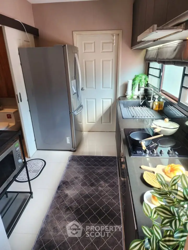 Modern kitchen with sleek appliances and ample natural light