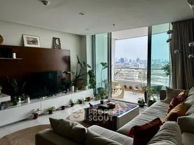 Spacious living room with city view and large balcony, featuring modern decor and abundant natural light.