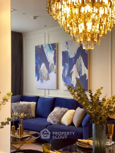 Luxurious living room with elegant chandelier and modern blue sofa