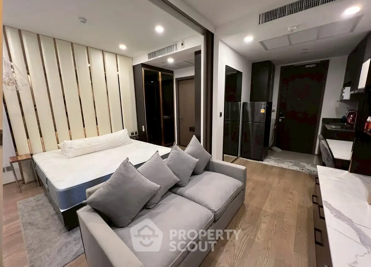 Modern studio apartment with stylish decor and open layout, featuring a cozy living area and sleek kitchen.