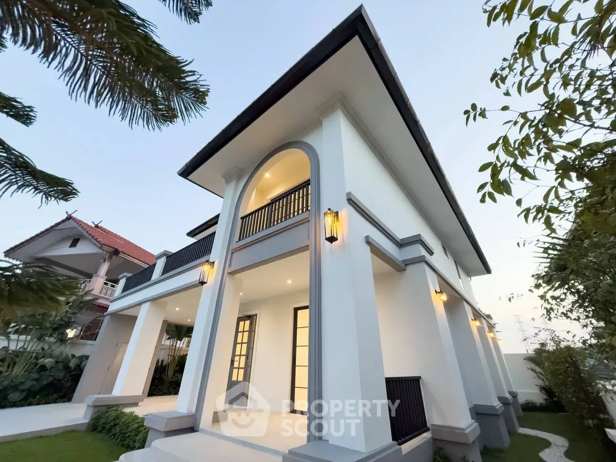 Stunning modern two-story house with elegant exterior lighting and lush greenery, perfect for luxurious living.