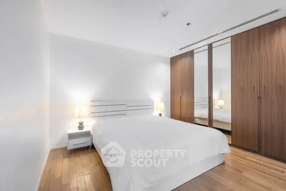 Modern bedroom with wooden floor and mirrored wardrobe