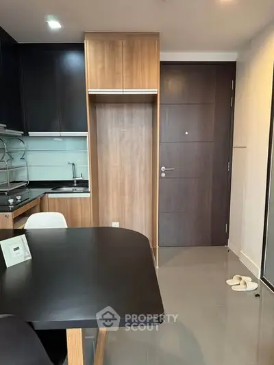Modern kitchen with sleek cabinetry and dining area in a stylish apartment.