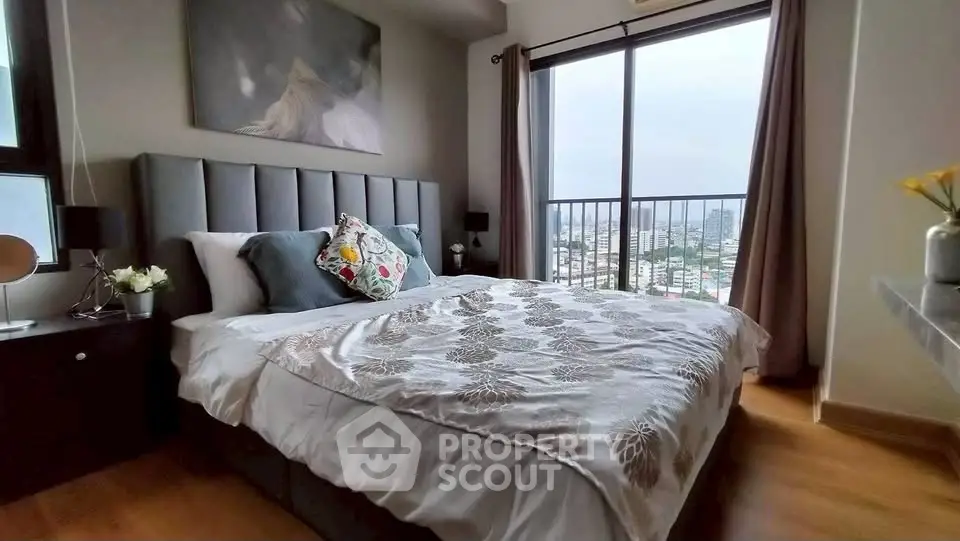 Luxurious bedroom with city view, elegant decor, and large windows for natural light.