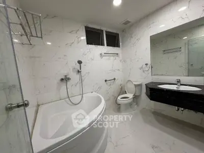 Luxurious marble bathroom with modern fixtures and spacious bathtub