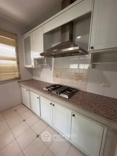 Charming kitchen with gas stove and elegant cabinetry, perfect for culinary enthusiasts.