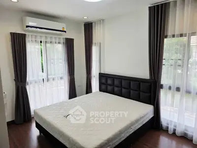 Spacious bedroom with large windows and modern decor in a stylish apartment.