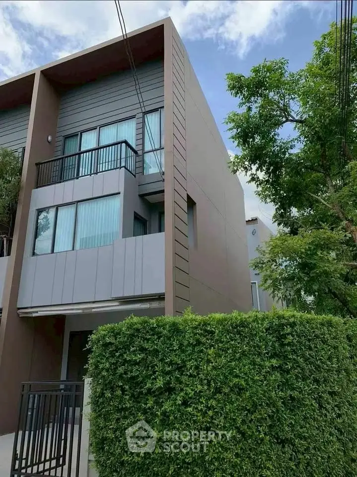 Modern townhouse exterior with lush greenery and sleek design