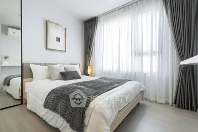 Modern bedroom with elegant decor and large window for natural light.