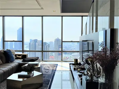Luxurious high-rise living room with floor-to-ceiling windows offering a panoramic city skyline view, modern furnishings, and sleek design.