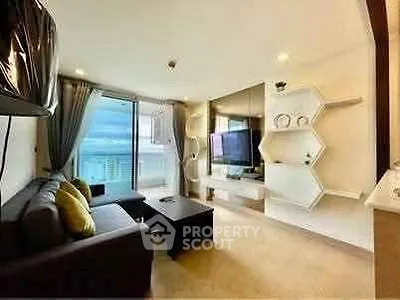 Modern living room with ocean view, stylish decor, and large TV, perfect for relaxation.