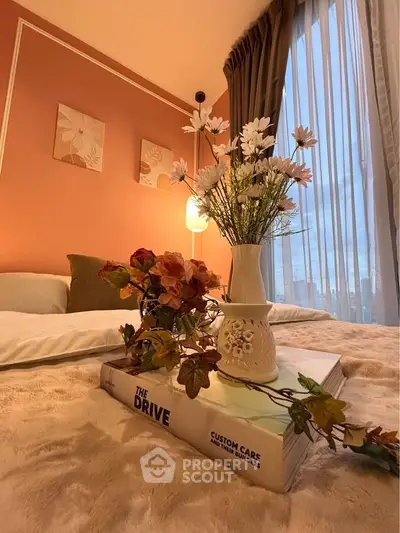 Cozy bedroom with elegant decor and city view, featuring soft lighting and floral accents.