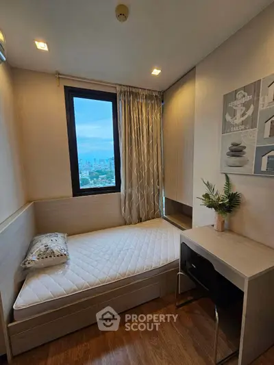 Cozy bedroom with city view, featuring a single bed, desk, and modern decor, perfect for urban living.