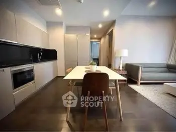 Modern open-layout kitchen and living room with sleek design and cozy seating area.