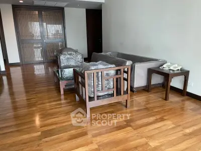 Spacious living room with wooden flooring and modern furniture, ideal for comfortable living.