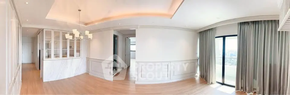 Spacious modern living room with elegant lighting and large windows offering stunning city views.