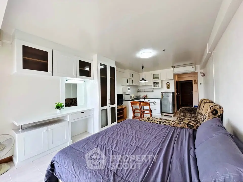Spacious studio apartment with modern kitchen and cozy living area, perfect for urban living.