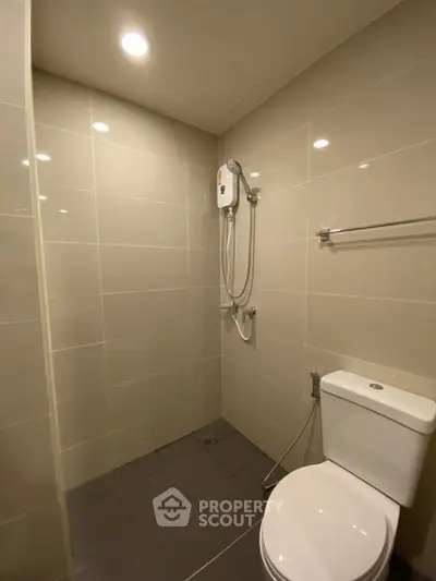 Modern bathroom with shower and toilet in sleek tiled design