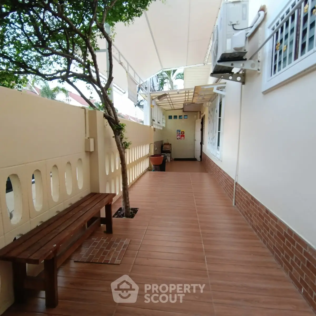 Charming outdoor corridor with wooden bench and tiled flooring, perfect for relaxation.