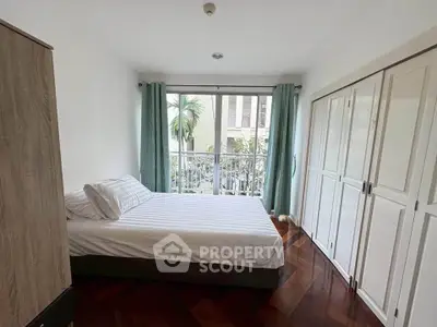 Bright and airy bedroom with large window and elegant wooden flooring