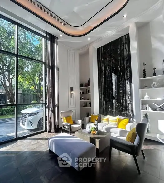 Luxurious living room with high ceilings, large windows, and elegant decor in a modern home.