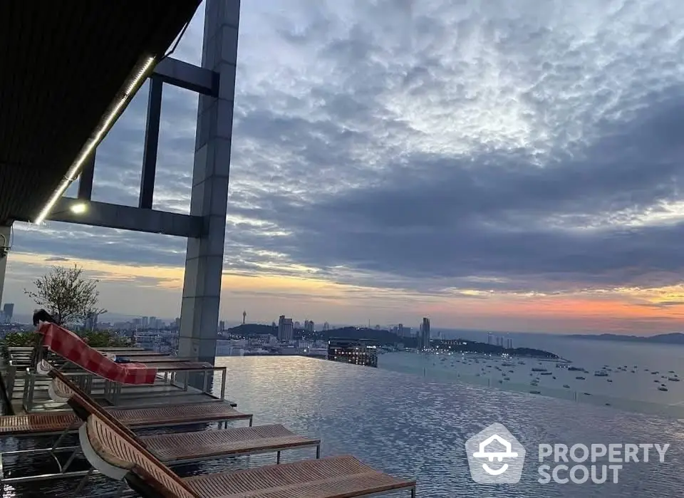 Stunning rooftop infinity pool with breathtaking city and ocean views at sunset.