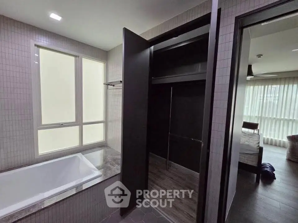 Modern bathroom with bathtub and walk-in closet in a stylish apartment.