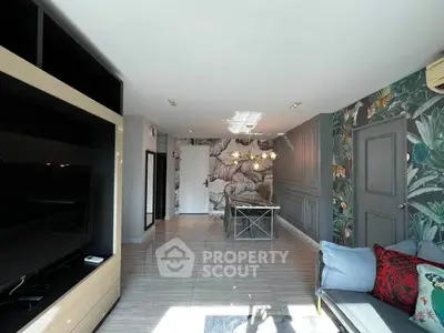 Stylish living room with modern decor and vibrant wallpaper, featuring a cozy seating area and sleek entertainment unit.