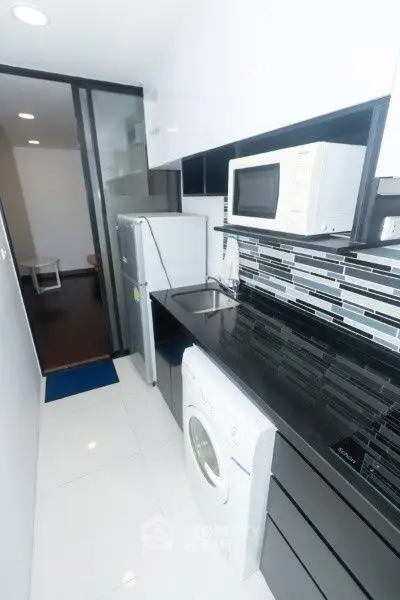 Modern kitchen with sleek black countertops and appliances