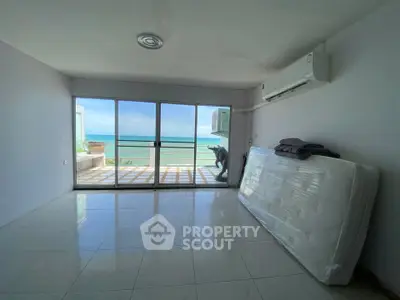 Spacious beachfront living room with stunning ocean view and large windows.