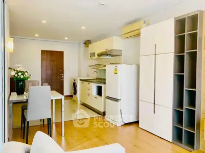 Modern open-layout kitchen with dining area and appliances in a cozy apartment setting.