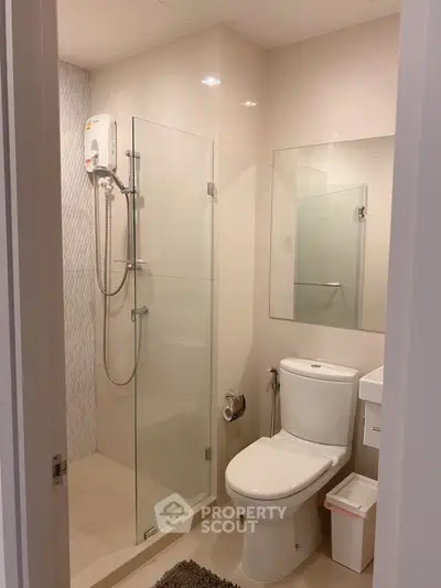 Modern bathroom with glass shower and sleek fixtures in a contemporary apartment.