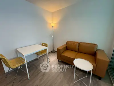 Modern living room with stylish brown sofa, white table, and chic lighting.