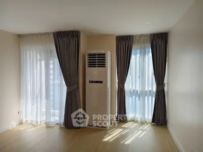 Bright empty room with large windows and air conditioner, ideal for customization.