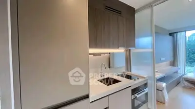 Modern compact kitchen with sleek cabinetry and integrated appliances in a stylish apartment.