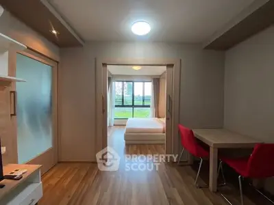Modern apartment interior with wooden flooring and stylish furniture, featuring a cozy bedroom and dining area.