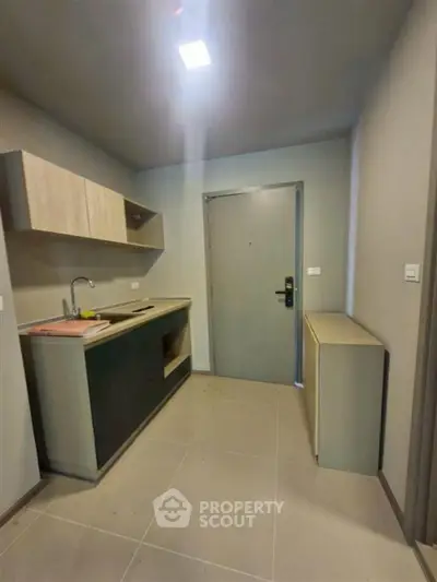 Modern kitchen with sleek cabinetry and minimalist design in a compact space.