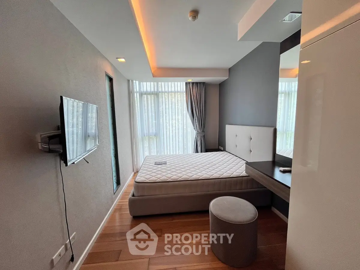 Modern bedroom with sleek design, featuring large windows and stylish furnishings.