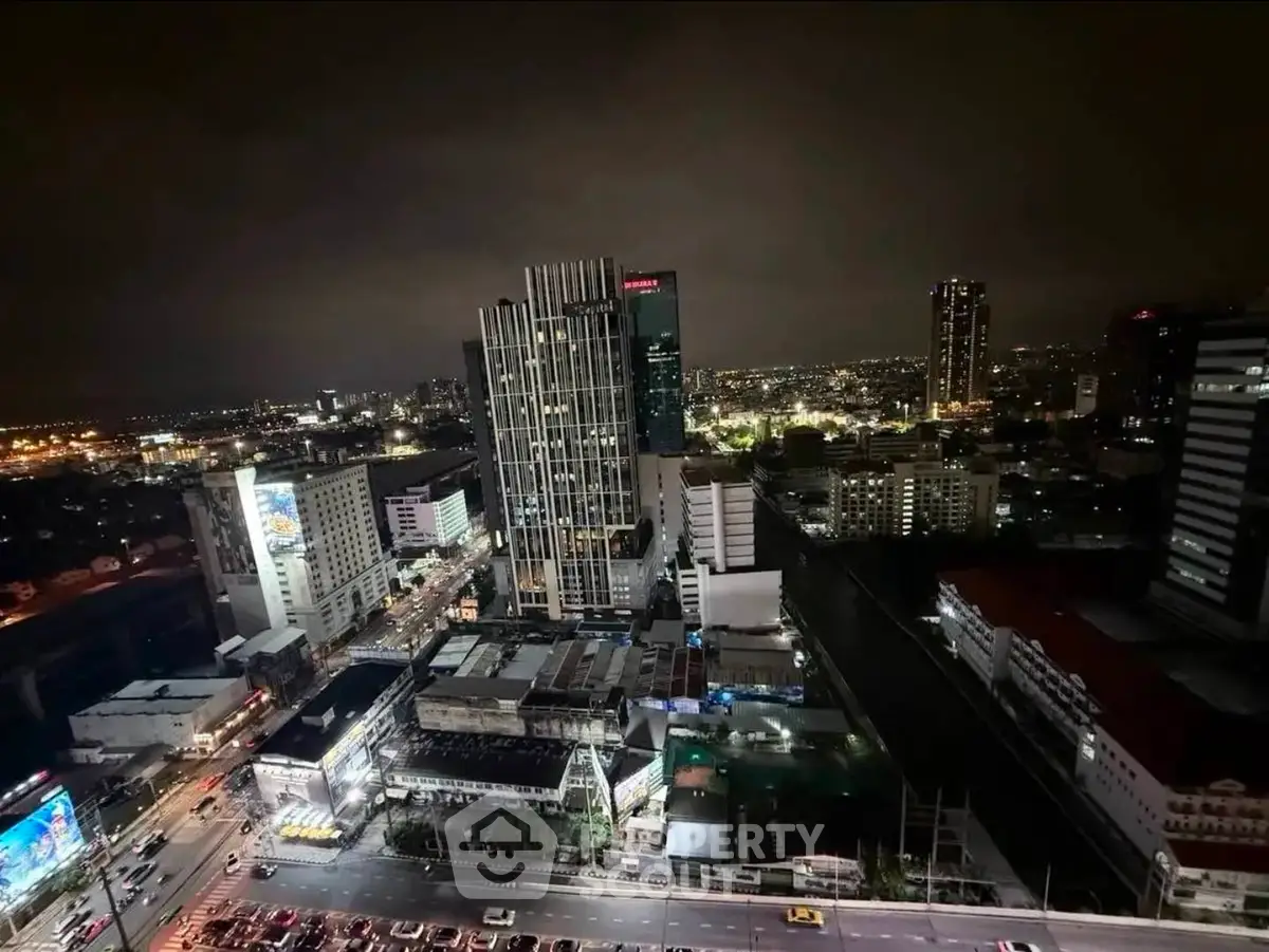 Stunning cityscape view from high-rise building at night with vibrant lights.